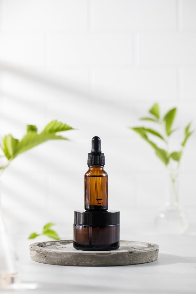 Brown jar of cream and a dropper with serum for facial skin with a natural composition against.