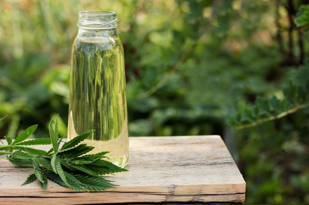 hemp oil in a glass jar with hemp leaf